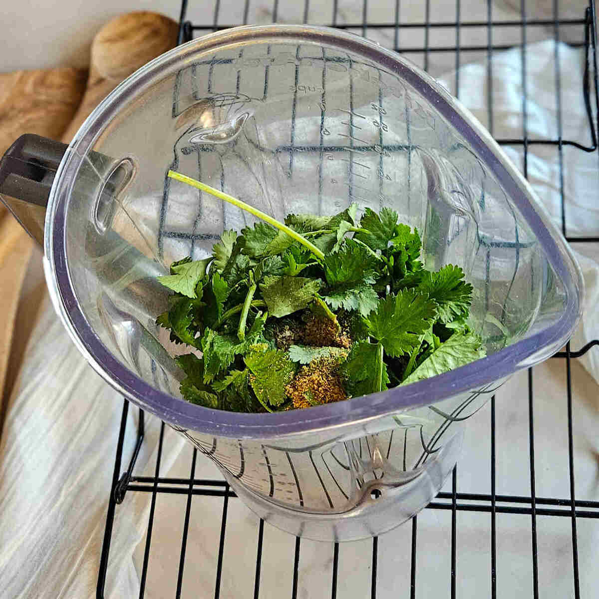 Cilantro, cumin, salt, and pepper in a blender for the roasted salsa Verde.