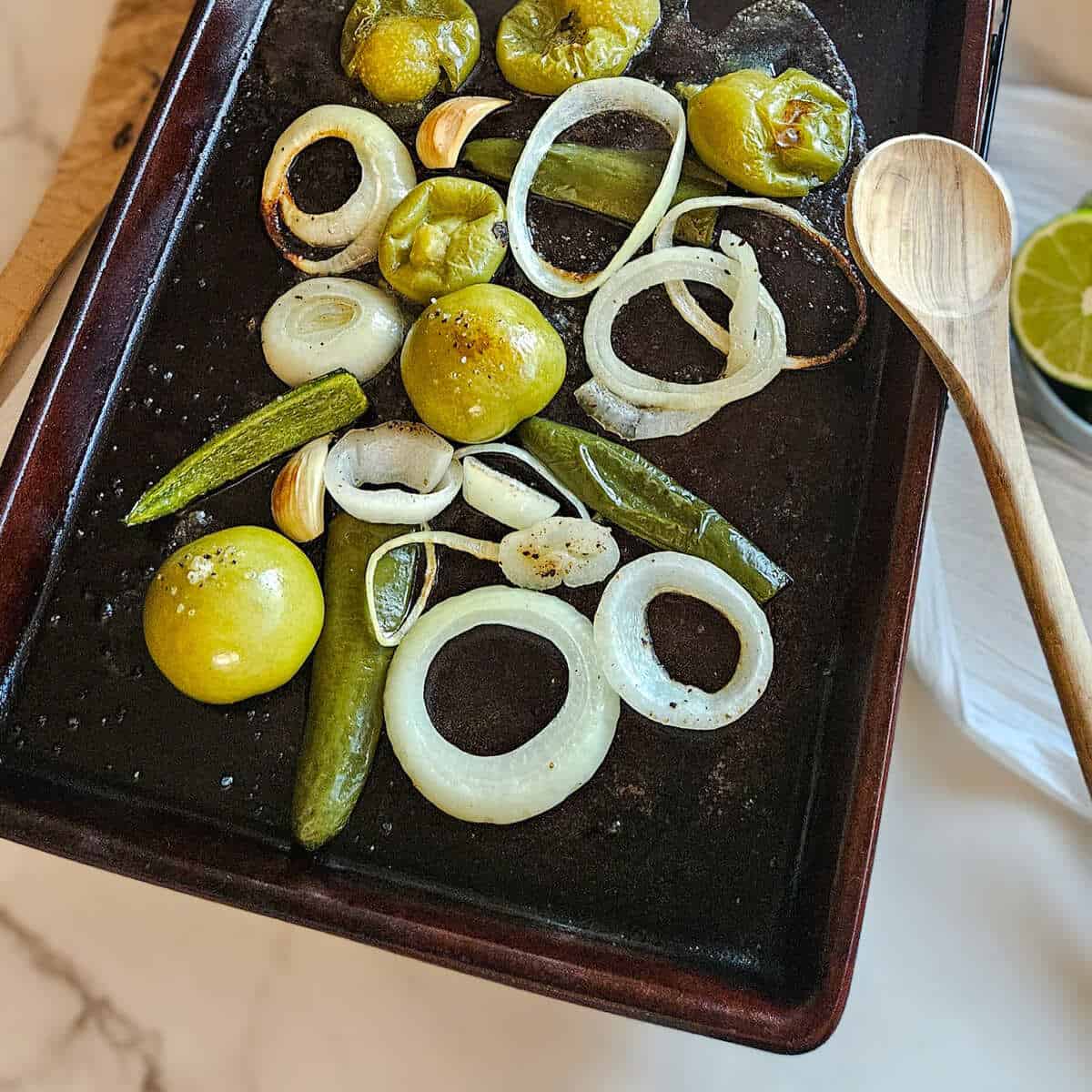 The roasted ingredients fresh out of the oven on a baking pan for homemade salsa verde.