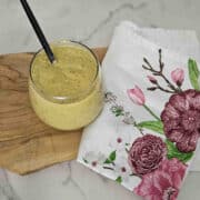 Charred lemon salad dressing in a jar with a spoon ready to serve.