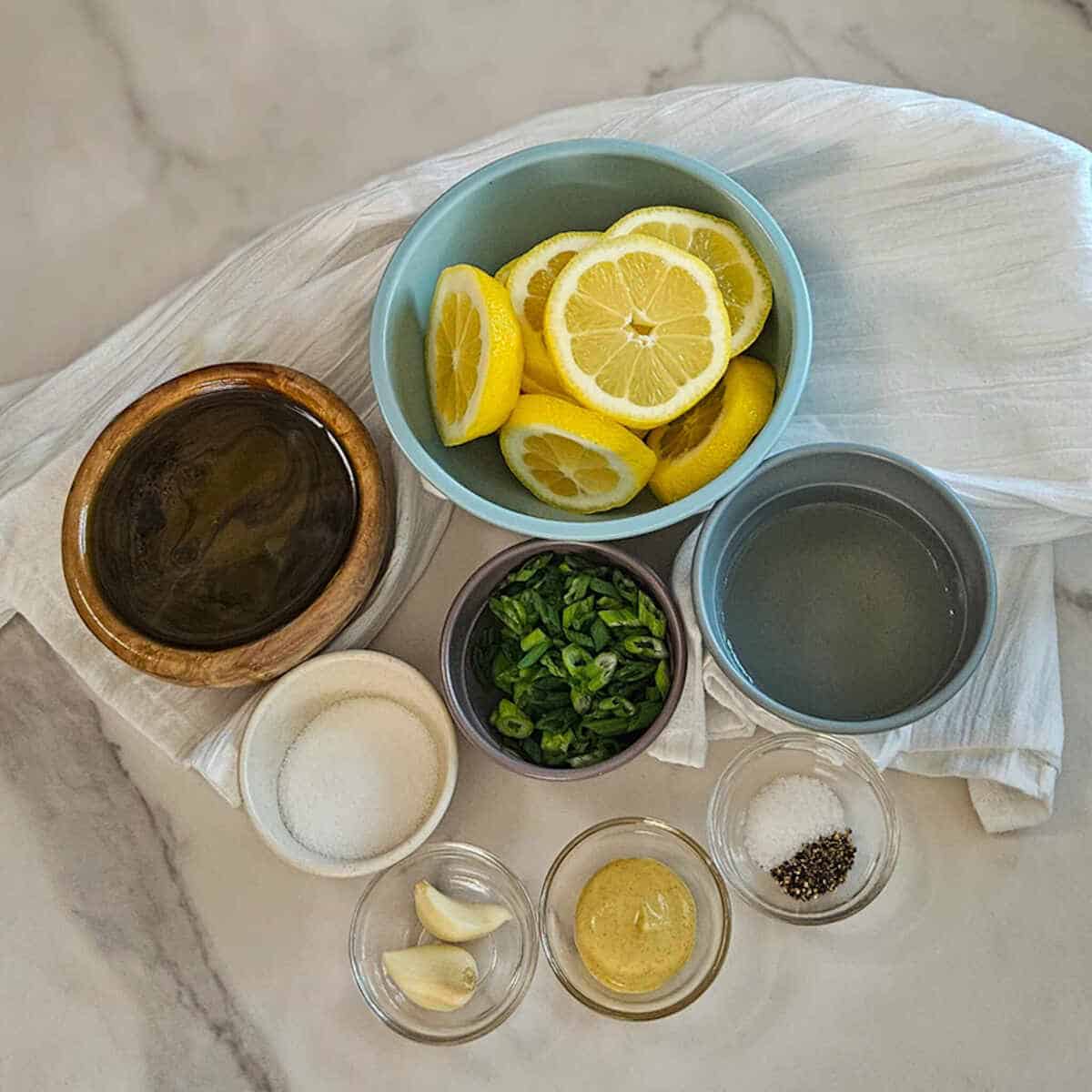 The ingredients for the charred lemon salad dressing recipe measured into bowls.