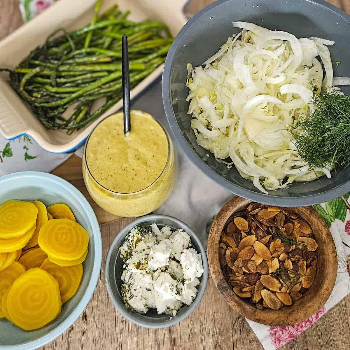 All of the ingredients for roasted asparagus and fennel salad with golden beets measured into bowls.