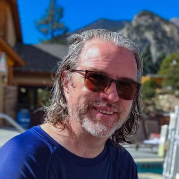 Jason Miller outside in the mountains with sunglasses on.