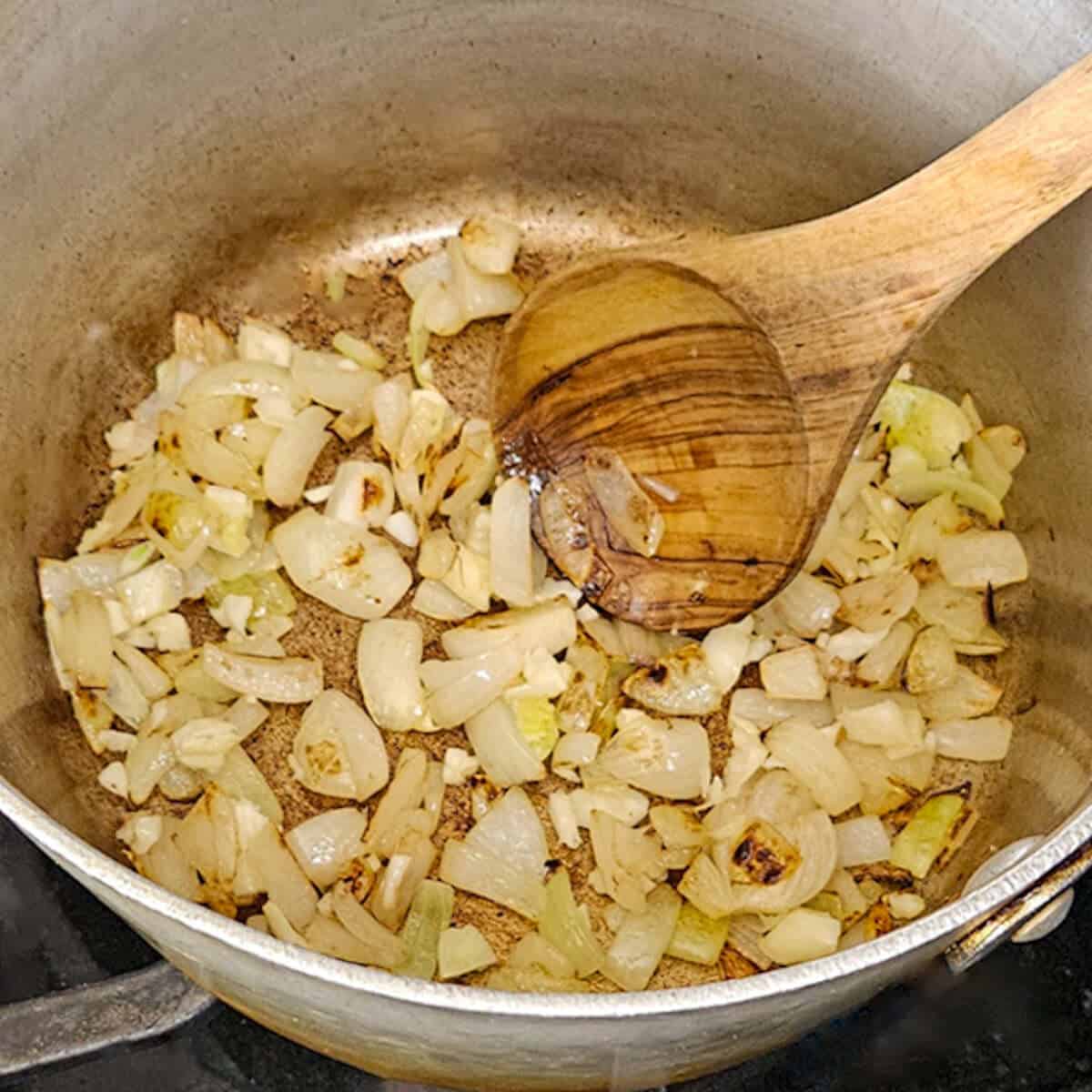 Sautéing chopped onions in a saucepan for delicious Season Two Taste recipes. Perfect for flavorful meal prep.