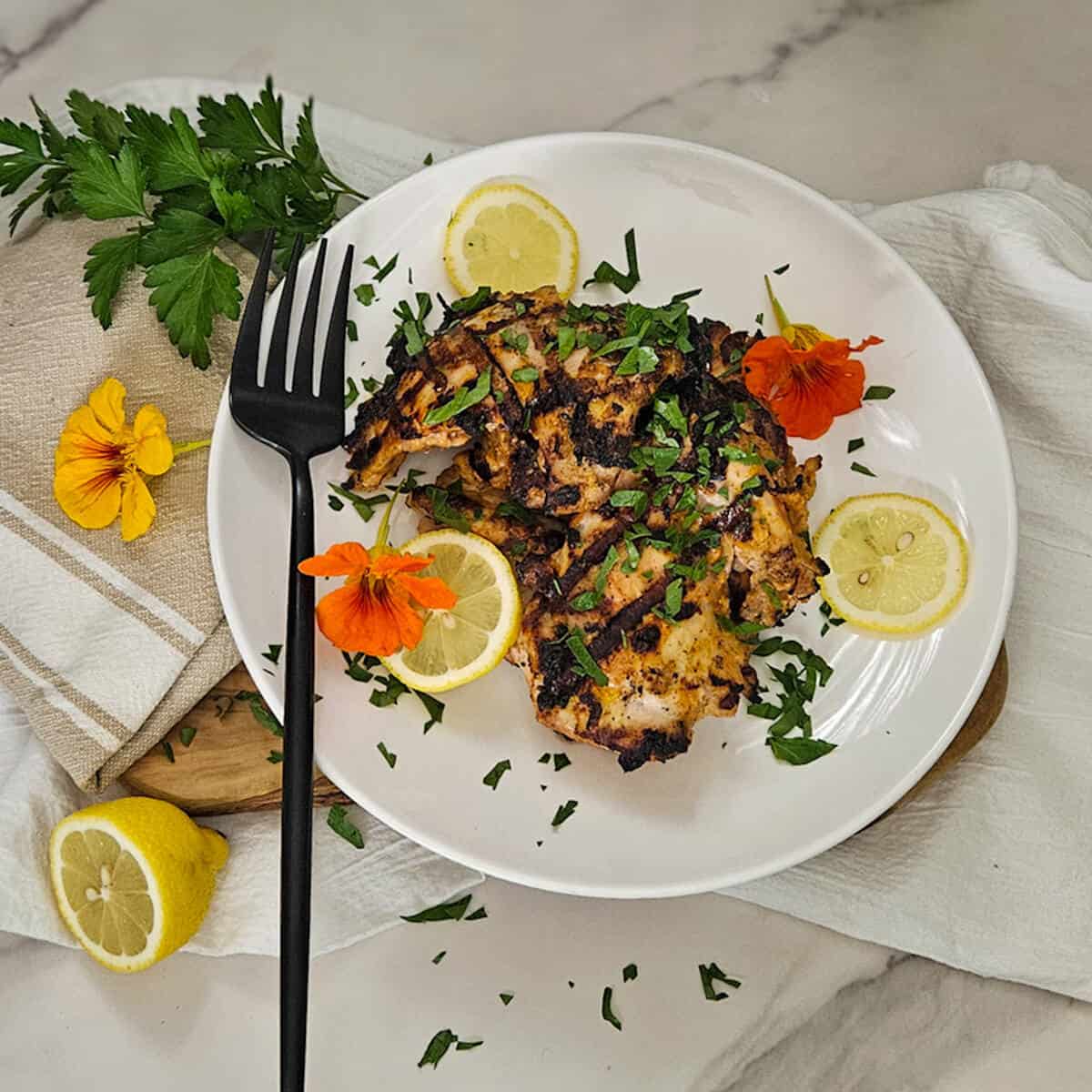 Grilled chicken dish with lemon slices and herbs, from Season Two Taste. Perfect for flavorful, healthy meals.
