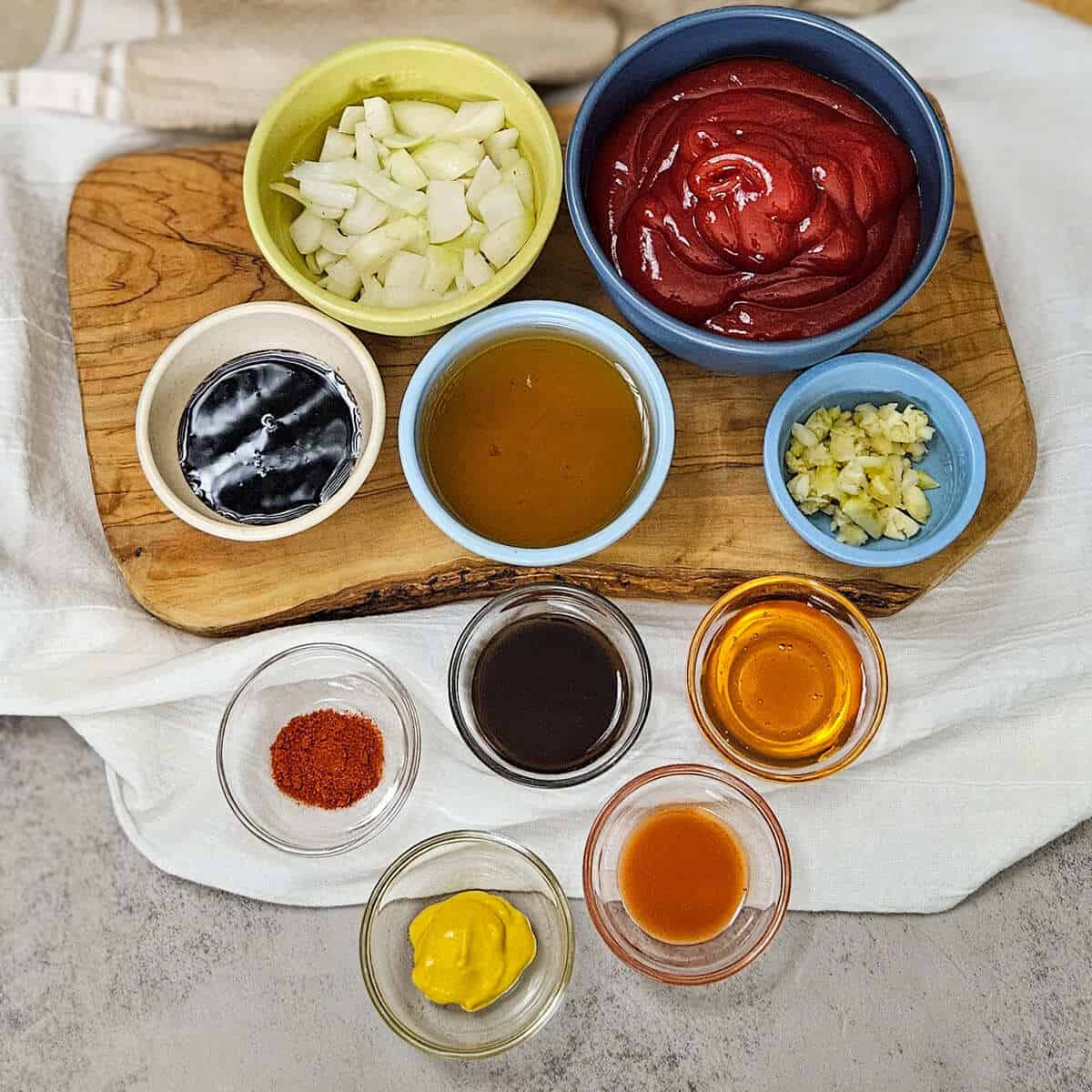 Fresh chopped onions and garlic with various sauces, spices, and condiments for homemade Kansas city BBQ sauce.