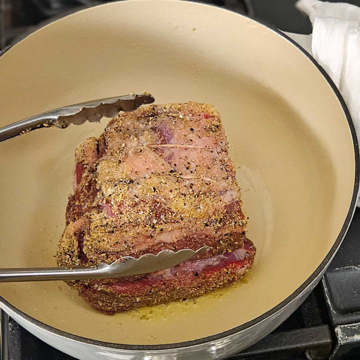 Juicy seasoned beef roast in a cast-iron skillet, ready for cooking or roasting.