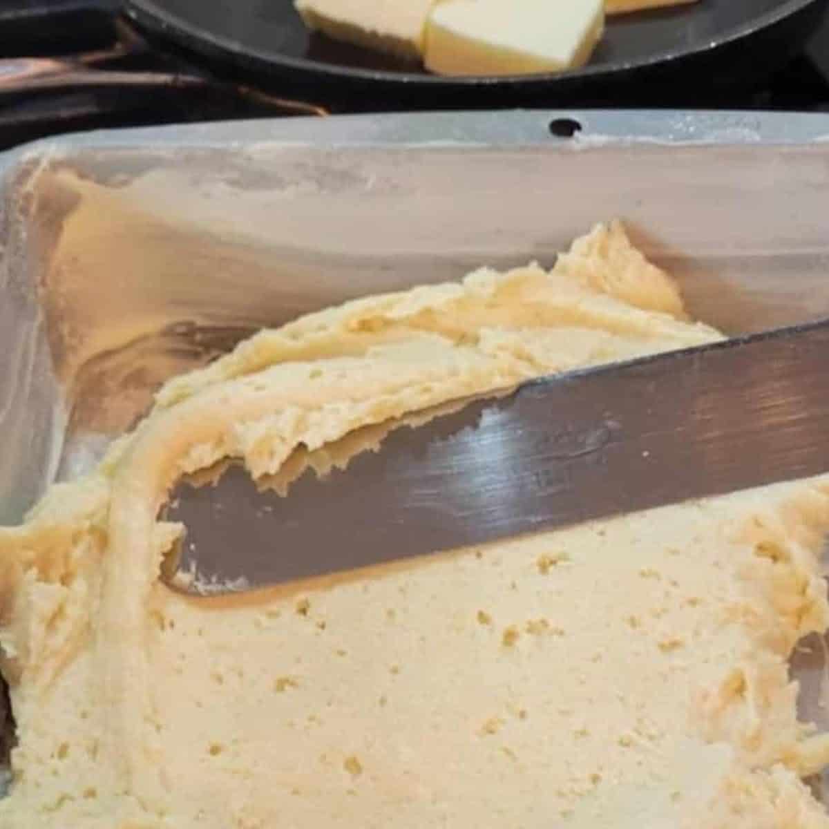 Spreading the batter into a prepared pan for the raspberry crumb buckle.