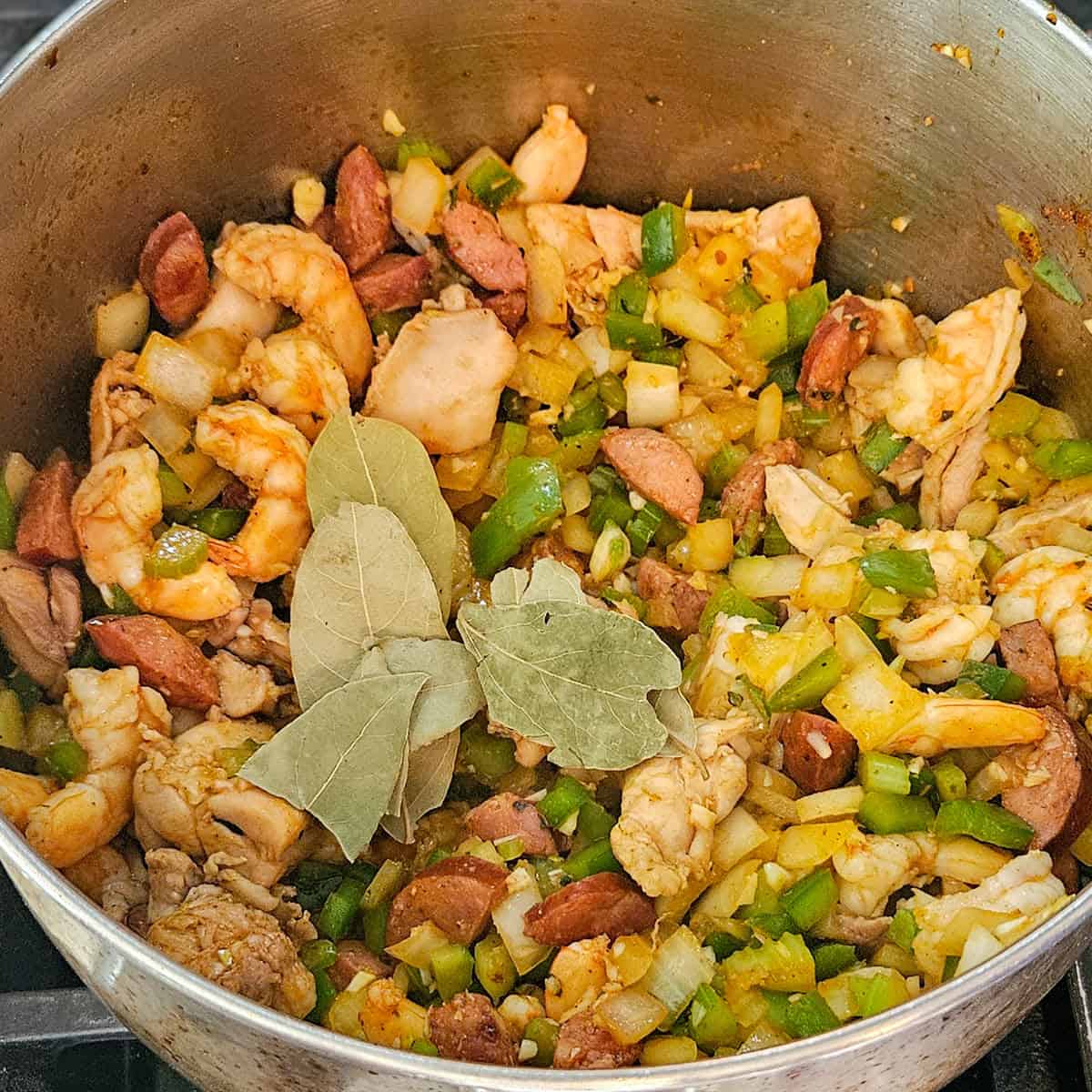 Shrimp, sausage, and vegetable stir-fry in a skillet.