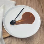 Dark roux on a plate with a spoon.