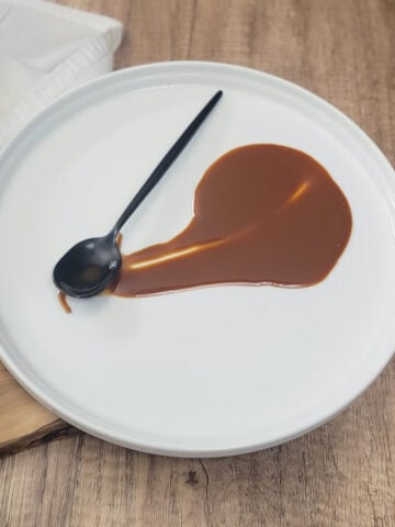 Dark roux on a plate with a spoon.