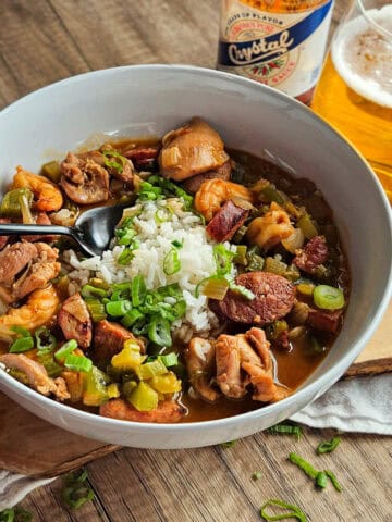 Delicious chicken and sausage gumbo served with rice, topped with fresh green onions.