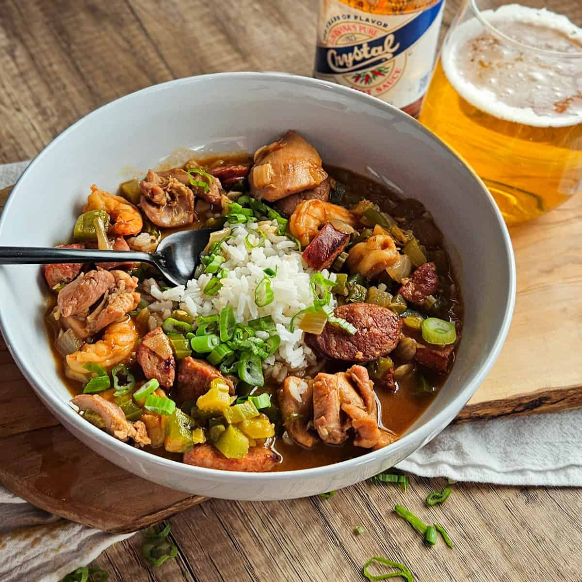 Delicious chicken and sausage gumbo served with rice, topped with fresh green onions.