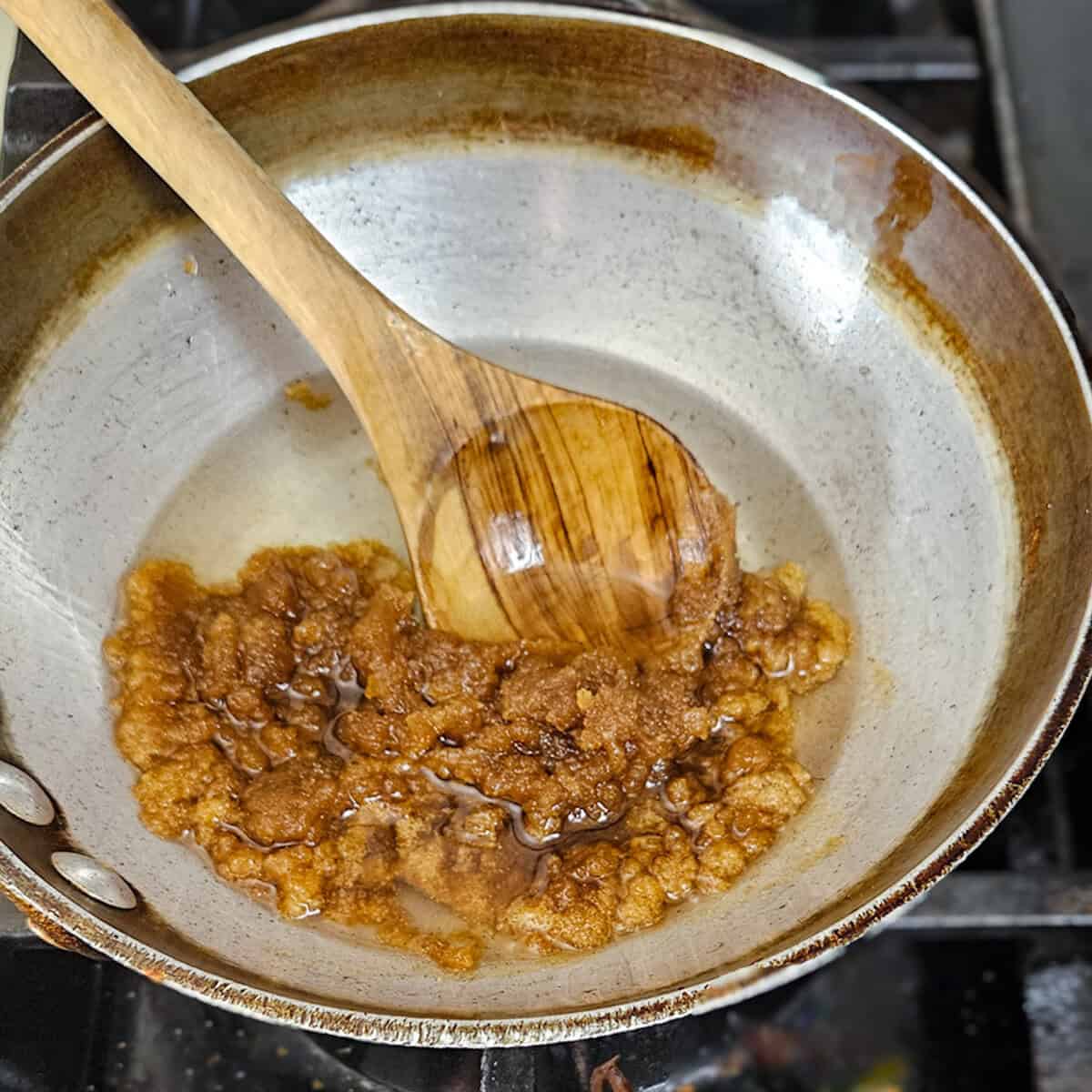 Melting coconut oil, brown sugar, and vanilla for chai spice granola.
