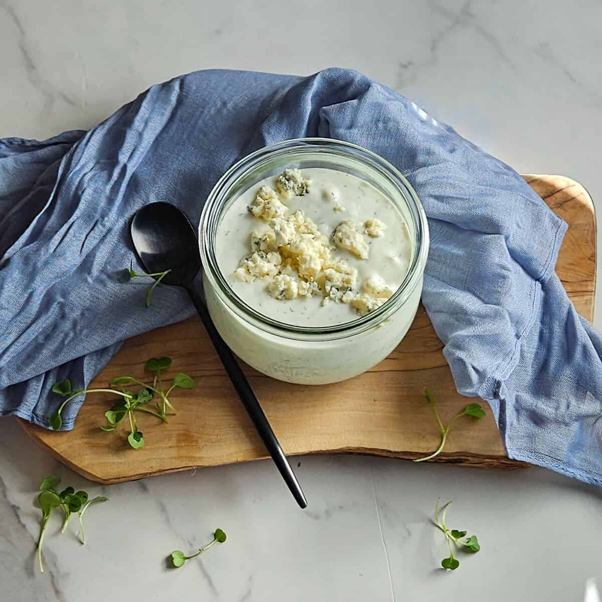 Delicious creamy blue cheese dip served in a glass jar with herbs.